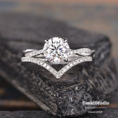 a diamond engagement ring sitting on top of a rock