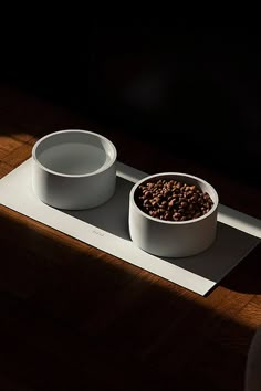 two bowls with food in them sit on a place mat