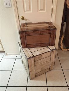 two wooden boxes sitting next to each other on the floor in front of a door