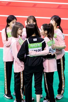 a group of young women standing next to each other on top of a basketball court