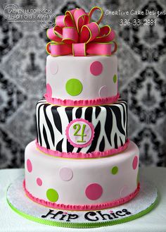 a three tiered cake decorated with zebra print and polka dots