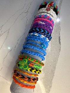 a bunch of bracelets that are laying on the ground in front of a pole