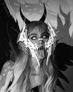 a woman with horns and wings on her head is making a face while wearing a mask