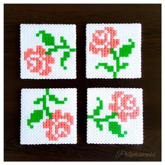 four cross stitch coasters with flowers on them