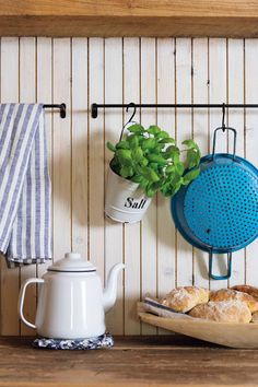 a potted plant sitting on top of a wooden shelf next to a teapot