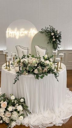 the table is set up with flowers and greenery for an elegant wedding reception or special event