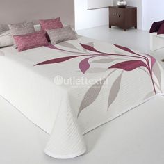 a white bed with pink and grey pillows