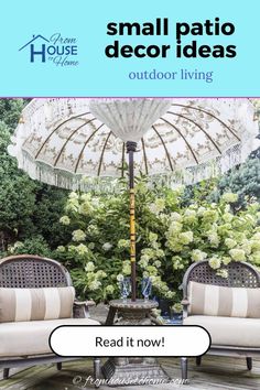 two chairs and an umbrella in the middle of a patio area with flowers on it