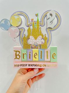 a person holding up a birthday card with a castle on it