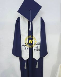 a blue and white graduation gown hanging on a wall