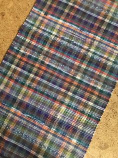 a multicolored plaid rug on the floor