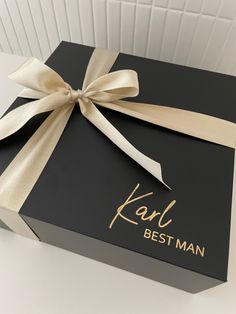 a black box with a gold ribbon and the words kal best man on it