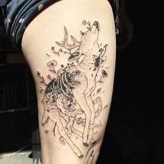 a woman's thigh with a tattoo of a deer and flowers on the side