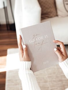 a woman holding up a book in her hands with the word color it on it