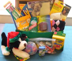 a teddy bear sitting next to a box filled with school supplies and other items on a table