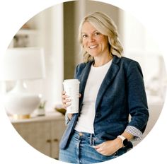 a woman is holding a coffee cup and smiling at the camera with her hands in her pockets