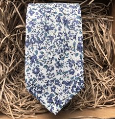 The Blue Scheherazade Floral Necktie in Cotton. This is a blue floral men's tie - perfect for weddings. We offer free shipping within the UK or a standard  WorldWide shipping cost of £3.99 to all countries outside of the UK. We also offer a free handwritten gift tag service - just leave the wording that you would like on the gift tag in the notes from buyer.  If you choose 'gift wrapping' we will send your item beautifully wrapped in a cardboard box with string and a gift tag with your message. We can also make all of our ties in children's sizes. Dimensions of tie: Tie width: 6cm   Tie length: 147cm   Also available in 8cm wide tie We offer a set of pre-made ties and pocket squares. The full set comprises of a bow tie, necktie and pocket square or each item can be bought individually. Our Blue Floral Tie, Husband To Be, Floral Necktie, Orange Bows, Grey Suit, Ties For Men, Floral Pocket, Men's Tie, Wedding Ties