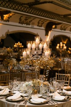 the tables are set with candles and place settings for an elegant wedding reception at the grand america hotel