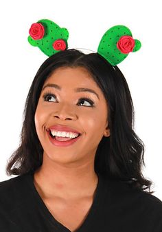 a woman is smiling and wearing green antlers on her head