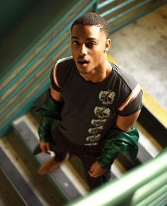 a young man in black shirt standing on stairs