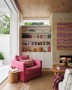 a living room filled with furniture and bookshelves next to a fire burning place