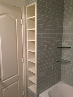 a white bath tub sitting in a bathroom next to a walk - in shower stall