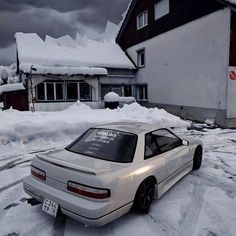 a white car is parked in the snow