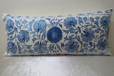 a blue and white pillow sitting on top of a bed