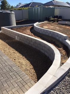 a brick retaining wall in the middle of a yard