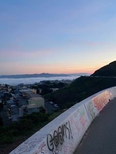 a skateboarder is doing tricks on the edge of a ramp with graffiti writing all over it