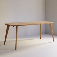 a wooden table sitting in front of a white wall with an object on it's legs