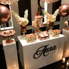 a table topped with cakes and desserts next to balloons