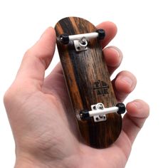 a person holding a wooden skateboard in their hand