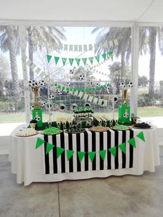 a table topped with lots of green and black desserts on top of a white table cloth