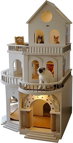 a cat is sitting on top of a doll house that has stairs to the second floor