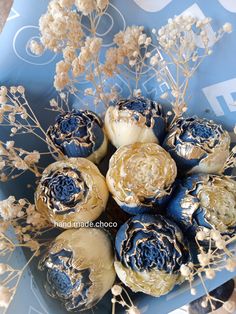 an arrangement of blue and white flowers in a bowl