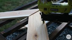 a cordless nailing machine on top of some wood