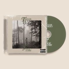 a cd cover with an image of a person standing in the middle of a forest