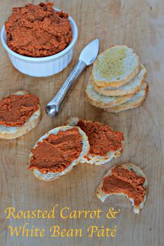 some bread with red stuff on it next to a bowl of dip and two spoons