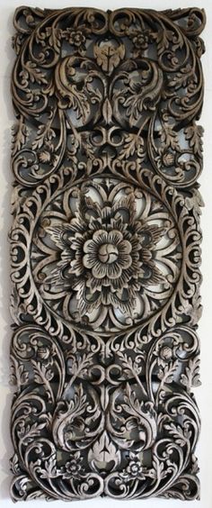 an intricately carved metal surface with flowers and leaves