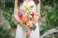 a woman holding a bouquet of flowers in her hands