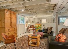 a living room filled with furniture and lots of wooden accents on the ceiling, along with an area rug