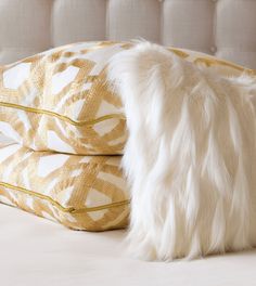 two pillows on top of each other with white fur