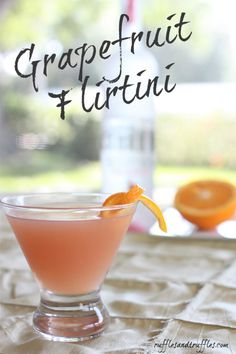 the grapefruit martini is garnished with an orange slice