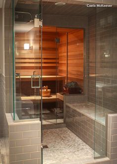 a glass enclosed sauna in the middle of a bathroom