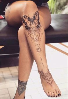 a woman sitting on top of a bench with butterfly tattoos on her leg and legs