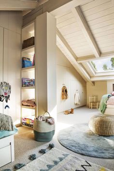 an attic bedroom with white walls and carpeted flooring, built in bookshelves