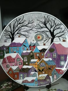 a decorative plate with houses painted on it