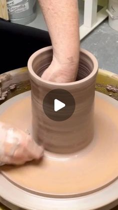 a person is making a vase on a pottery wheel with their thumb in the middle