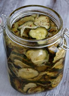 pickled cucumbers in a glass jar on a wooden table